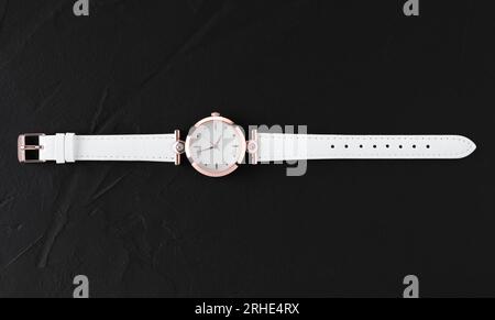 Montre-bracelet femme blanche de luxe sur fond noir gros plan Banque D'Images