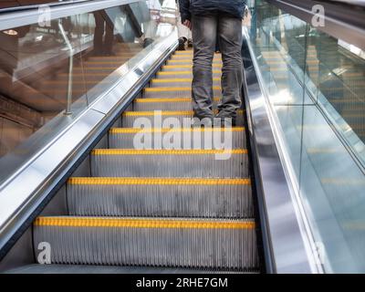 Photographie candide de personnes debout sur un escalier roulant en train de monter, prise dans le centre de Londres dans un centre commercial Banque D'Images