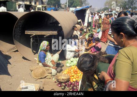 Les gens devant une grande conduite d'eau au marché alimentaire dans la ville de Surat dans la province du Gujarat en Inde. Inde, Gujarat, avril 1998 Banque D'Images