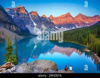 Jeune couple appréciant Alpenglow au lac Moraine en été dans le parc national Banff, Rocheuses canadiennes, Alberta, Canada. Parc national Banff, Albert Banque D'Images