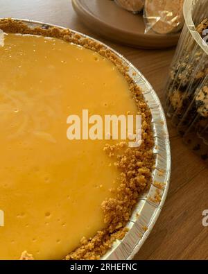 cheesecake au citron, sur table en bois, dessert frais délicieux, avec base de biscuit moulu, type tarte Banque D'Images