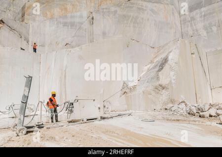 belle et artistique photographie d'une mine de marbre. y compris les hommes travaillant avec de la machinerie lourde Banque D'Images