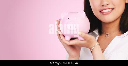 Femme, tirelire et maquette espace dans l'épargne, l'investissement ou la croissance financière sur un fond de studio rose. Personne féminine, bannière et mains Banque D'Images