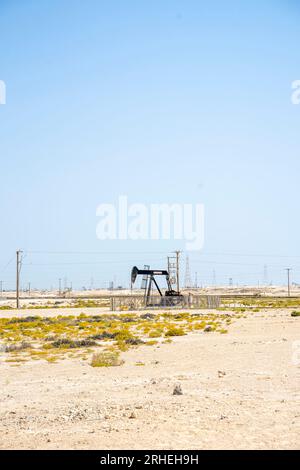 Infrastructure de champ pétrolier de Bahreïn - vérin de pompe, cheval de pétrole, vérin de pétrole, pompe de faisceau extrayant le pétrole brut du puits de pétrole dans le désert de Bahreïn Banque D'Images