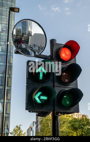 Londres, Royaume-Uni : feu rouge avec des feux filtrants verts à Londres. Feu stop avec miroir réfléchissant le trafic en attente. Banque D'Images