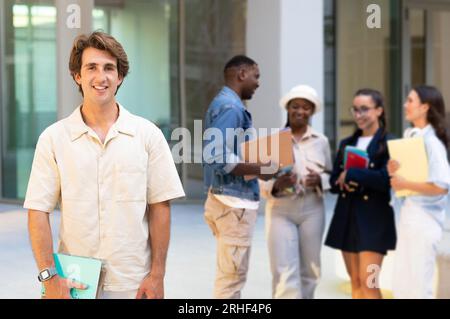 Beau gars européen posant sur un groupe multiracial d'étudiants Banque D'Images