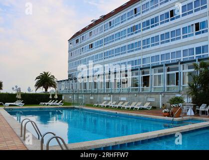 Chaises longues vides à côté de la piscine dans la lumière du soir à l'arrière de l'Hôtel Louxo Hôtel 4 étoiles la Toja Île Pontevedra Galice Espagne Banque D'Images