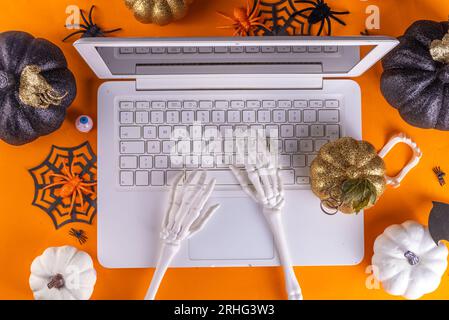 Espace de travail amusant pour Halloween avec pose à plat pour ordinateur portable. Office corporation Halloween partie invitation, blogger automne vacances fond. Ordinateur portable blanc avec Ha Banque D'Images