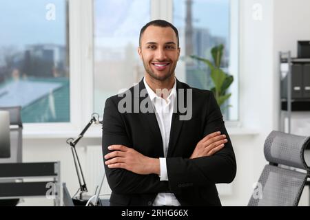 Jeune homme d'affaires souriant dans son bureau moderne Banque D'Images