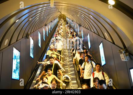 ZHANGJIAJIE, CHINE - 9 AOÛT 2023 - les touristes montent à bord d'un escalator à travers les montagnes pour visiter la région pittoresque de la montagne Tianmen à Zhangjiajie, Hunan Banque D'Images