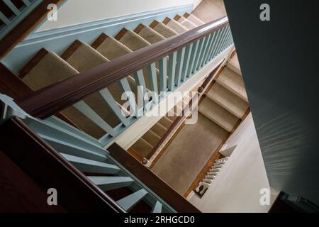 Une vue de haut en bas d'un vieil escalier en bois à l'intérieur d'une maison abandonnée. Banque D'Images