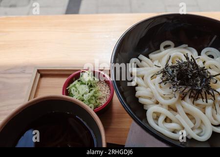 Nouilles Soba froides japonaises avec sauce trempée sur une table en bois extérieure sur le trottoir. Banque D'Images