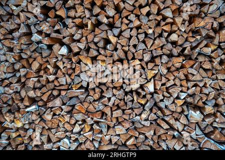 Arrière-plan des billes de bois empilées hachées. Pile de bois prêt pour l'hiver. Souches en bois, bois de chauffage empilé dans le tas Banque D'Images