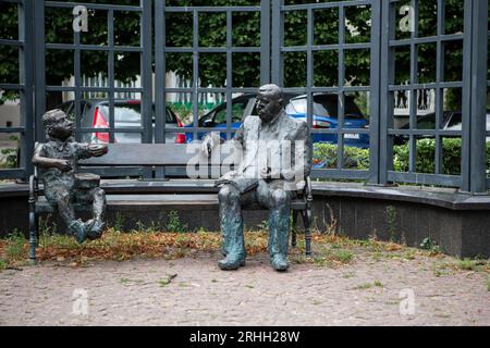 DAS Denkmal zeigt Günther Grass, sitzend auf einer Bank, während neben ihm Oskar Matzerath, die zentrale figur aus seinem berühmten Roman 'Die Blechtr Banque D'Images