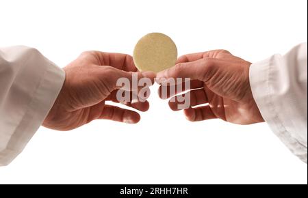 Mains d'un prêtre consacrant une armée comme le corps du Christ pour la distribuer aux communiants avec fond blanc isolé. Banque D'Images