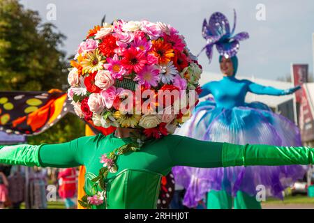 Un greeter portant une coiffe florale ornée de fleurs. Un festival lumineux et coloré de 2023 dans le nord-ouest les visiteurs sont accueillis au spectacle botanique par des marcheurs sur pilotis floraux à leur arrivée pour les quatre jours des magnifiques expositions de fleurs. Southport Merseyside, Royaume-Uni Banque D'Images