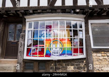 Lincoln Pride drapeau dans la fenêtre du magasin d'information touristique Leigh - Pemberton House, Castle Hill, Lincoln City, Lincolnshire, Angleterre, ROYAUME-UNI Banque D'Images