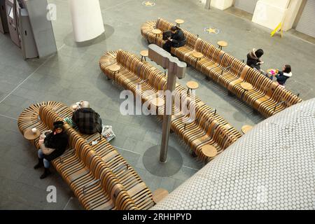 Les gens s’assoient sur des bancs dans une station King’s Cross tranquille à Londres. Banque D'Images