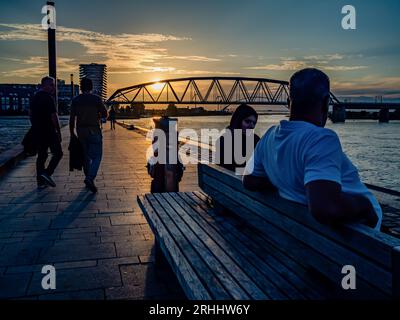 Nijmegen, pays-Bas. 14 août 2023. Un couple est vu se reposer sur un banc tout en regardant le coucher du soleil. Après plusieurs semaines changeantes, les pays-Bas peuvent s’attendre à ce que la météo estivale commence cette semaine. Les températures ont augmenté avec beaucoup de place pour le soleil. Dans les jours suivants, il restera principalement sec et le soleil brillera abondamment de sorte que des températures comprises entre 22 et 28 degrés peuvent être attendues. (Photo Ana Fernandez/SOPA Images/Sipa USA) crédit : SIPA USA/Alamy Live News Banque D'Images