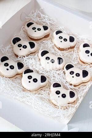 Macarons noirs et blancs sur le thème Panda ou biscuits dans une boîte cadeau. Cadeau doux pour l'anniversaire de bébé Banque D'Images