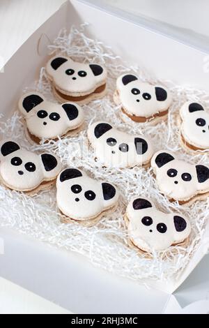 Macarons noirs et blancs sur le thème Panda ou biscuits dans une boîte cadeau. Cadeau doux pour l'anniversaire de bébé Banque D'Images