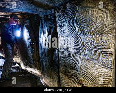 Visite guidée aux flambeaux GAVRINIS GUIDE de sculptures en pierre de l'intérieur de la texture, la France Bretagne cairn préhistorique, dolmen, tombe en pierre sèche, avec le célèbre et symbolique de l'âge de pierre mystérieux sculptures. Un des exemples les plus remarquables de la première apparition de l'architecture dans le monde occidental. Cairn de Gavrinis Cale de Penn-Lannic Sagemor larmor baden, Bretagne France (Megalithes du Morbihan) Banque D'Images