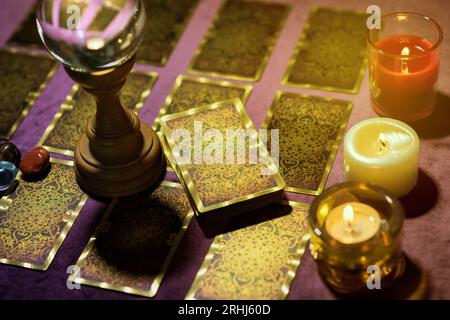 Du dessus du jeu de cartes de tarot avec boule de cristal et bougies allumées placées sur la table de la diseuse de fortune Banque D'Images