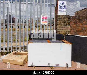 Fly tip sous un panneau avertissant que le basculement de mouche est un crime dans une rue près de Greenwich à Londres Royaume-Uni Banque D'Images