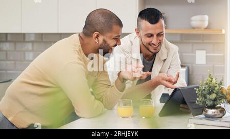 Sourire, streaming et un couple gay avec une tablette dans une cuisine pour une vidéo drôle ou les médias sociaux. Heureux, maison et lgbt hommes avec la technologie pour Banque D'Images