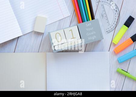 01 septembre. Image d'un calendrier en bois pour septembre 1 sur la table, vue de dessus. Jour d'automne. Retour à l'école. Papeterie et calendrier perpétuel Banque D'Images