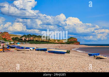 Bateaux colorés sur la plage de Budleigh Salterton regardant vers l'est vers l'embouchure de la rivière Otter et Otterton Ledge promontoire , Devon, Angleterre, Royaume-Uni Banque D'Images