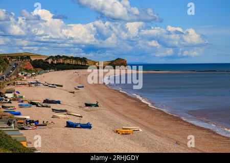 Bateaux colorés sur la plage de Budleigh Salterton regardant vers l'est vers l'embouchure de la rivière Otter et Otterton Ledge promontoire , Devon, Angleterre, Royaume-Uni Banque D'Images