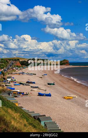 Bateaux colorés sur la plage de Budleigh Salterton regardant vers l'est vers l'embouchure de la rivière Otter et Otterton Ledge promontoire , Devon, Angleterre, Royaume-Uni Banque D'Images