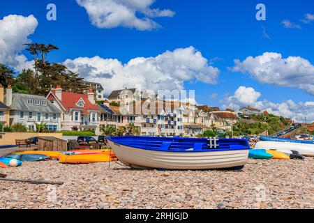 Bateaux colorés sur la plage de Budleigh Salterton regardant vers l'est vers l'embouchure de la rivière Otter et Otterton Ledge promontoire , Devon, Angleterre, Royaume-Uni Banque D'Images