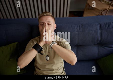 Soldat déprimé souffrant de TSPT militaire couvrant le visage avec les mains Banque D'Images