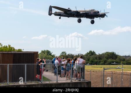 Aéroport de Londres Southend, Essex, Royaume-Uni. 17 août 2023. Les anciens avions Battle of Britain Memorial Flight de la RAF utilisent l’aéroport civil relativement calme d’Essex pour opérer à partir des spectacles aériens en bord de mer de ce week-end à Eastbourne et Folkestone. Le bombardier Avro Lancaster est représenté en train d'atterrir, en passant par les gens qui sont venus les voir arriver Banque D'Images