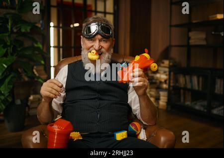 Portrait de fou drôle homme d'affaires senior avec des jouets en action Banque D'Images