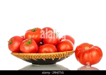 Plusieurs tomates rouges mûres dans une assiette en céramique, gros plan, isolées sur fond blanc. Banque D'Images