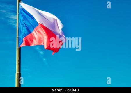 Un drapeau tchèque abaissé flotte dans le vent. Banque D'Images