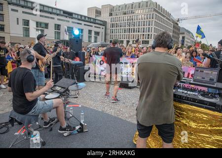 17 août 2023, Berlin, Allemagne : le 17 août 2023, la porte de Brandebourg, symbole d'unité et de paix, est devenue la toile de fond d'une puissante manifestation de solidarité et de résistance. Les pionniers du hip-hop ukrainien, TNMK (Tanok na Maidani Kongo), sont montés sur scène dans un concert de charité qui a été autant une extravagance musicale qu’une déclaration politique. La soirée a été chargée d'émotion alors que les Ukrainiens se rassemblaient, beaucoup brandissant des drapeaux ukrainiens, pour soutenir la cause de la liberté de l'Ukraine. L'air était épais de chants de ''la Russie est un État terroriste'', un sentiment que beaucoup de participants ont fait écho. Un massif Banque D'Images
