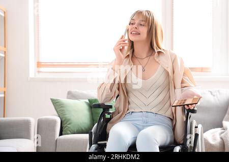 Jeune femme en fauteuil roulant se maquillant à la maison Banque D'Images