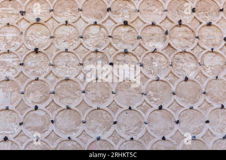 Façade ornementale en pierre de l'Alcazar de Ségovie, Espagne. Ornements islamiques avec motifs circulaires de sgraffites, cercles sculptés sur mur de pierre. Banque D'Images