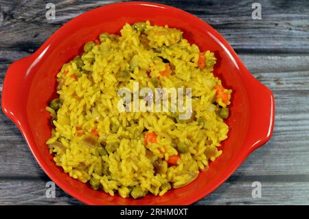 Une assiette de riz Basmati jaune chaud à grain long avec des légumes, des petits pois et des carottes avec des tranches d'oignon, une recette de cuisine chinoise et aussi d'Orient Banque D'Images