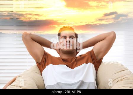 Homme aux yeux fermés en fauteuil et beau coucher de soleil, double exposition. Etat de pleine conscience Banque D'Images