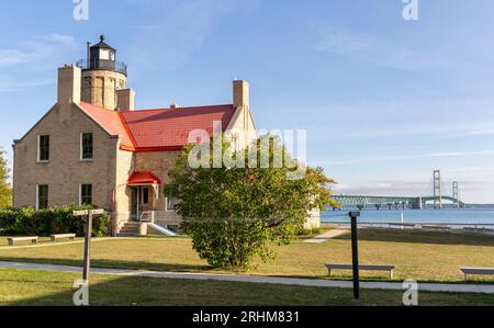 Vieux phare de Mackinaw City avec le pont Mackinaw au loin Banque D'Images