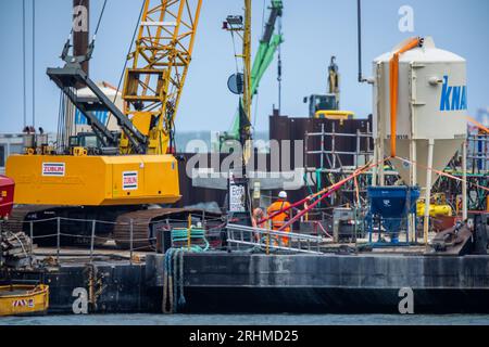 Prerow, Allemagne. 10 août 2023. Des grues sont utilisées pour assembler des structures en béton pour le nouveau port de l'île en face de la plage de la mer Baltique. Des sections de construction cruciales pour le nouveau port de l'île ont déjà été achevées et toutes les piles de soutien nécessaires pour la jetée ont été installées. Le port de l'île devrait ouvrir pour la saison des sports nautiques 2024 comme prévu. Le port en forme de goutte remplacera à l'avenir le port d'urgence de Darßer Ort. Crédit : Jens Büttner/dpa/Alamy Live News Banque D'Images