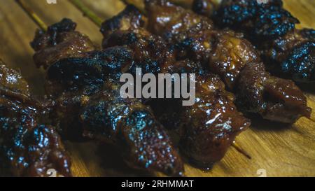 Sate ayam ou satay poulet servi sur une assiette en bois. gros plan Banque D'Images