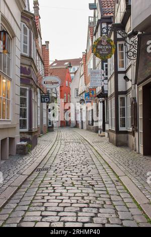 Rue étroite dans le quartier historique Schnoor de Brême. Vieille ville vide avec des magasins et des maisons à Brême. Bâtiments médiévaux avec des fleurs sur le mur. Banque D'Images