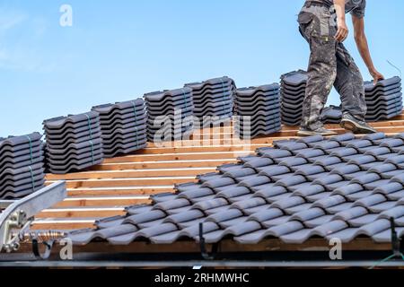 artisan posant des carreaux de céramique cuits sur le toit Banque D'Images