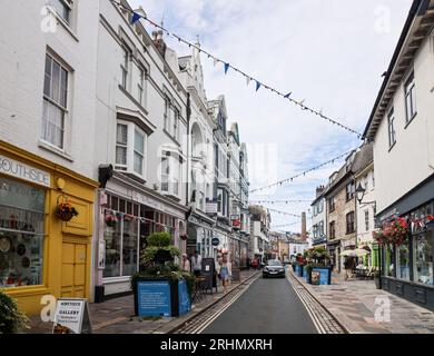 Les bacs à fleurs et les banderoles apportent une ambiance festive à Southside Street, sur le Barbican historique de Plymouth. Un mélange original de petits magasins, de maisons publiques et de r Banque D'Images